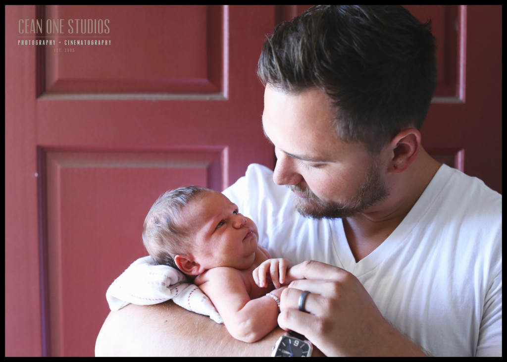 dad holding newborn by door fathers day pictures | San Diego Photographer